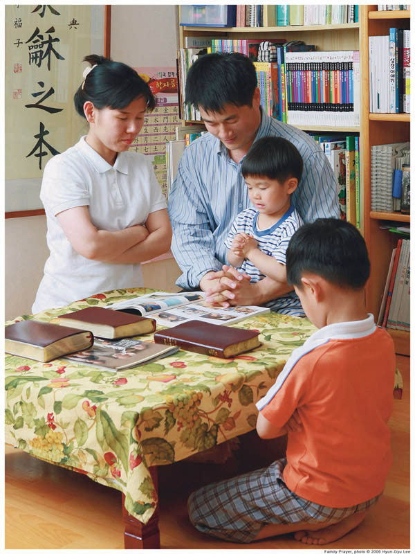 Tradional families provide the best outcome for children. Mother, father, children praying.