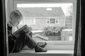 homeschooler reading in window seat