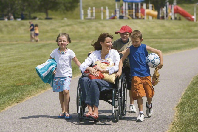 Mother in wheelchair at park with children
