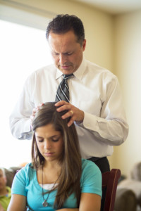 Young woman receiving priesthood blessing