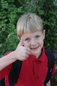 Boy with backpack giving thumbs up