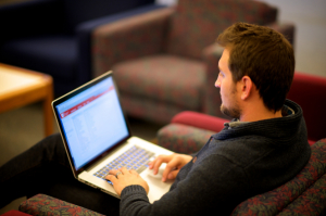 man writing on computer